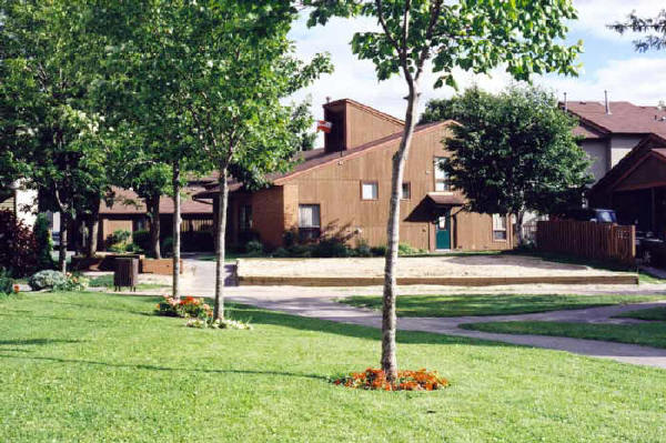 From beside Co-op garage showing back of community center and sandbox (now includes play structure)